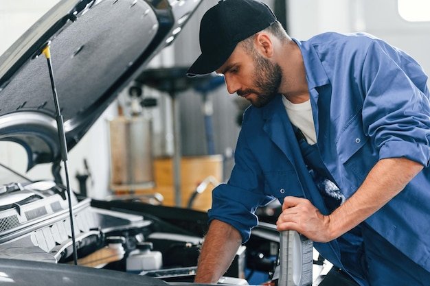 With fuel can Auto mechanic working in garage Repair service