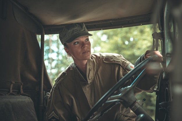 Woman in a military uniform in an army car.