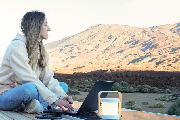 Woman Sitting on Table With Laptop in Front of Teide Mountain