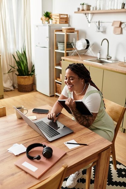 Young african american woman enjoys freelance work at cozy home office