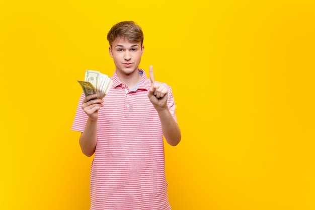 Young blonde man with dollar banknotes