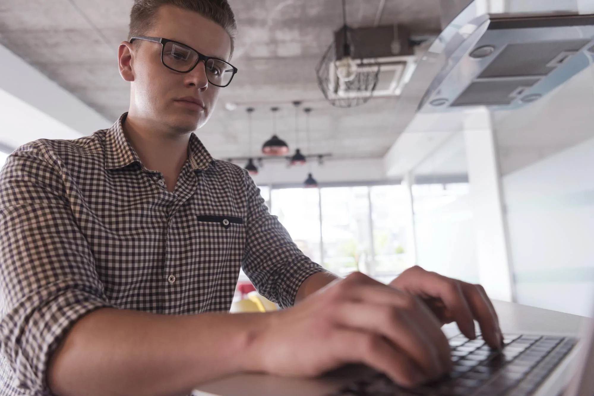 young businessman with glasses at startup business office space working on modern laptop computer