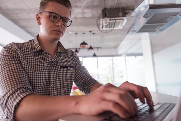 young businessman with glasses at  startup business office space working on modern  laptop  computer