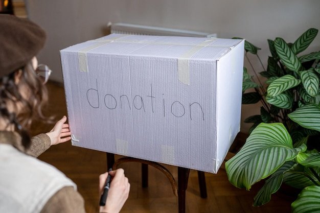 Young woman organizing stuff for donation before move