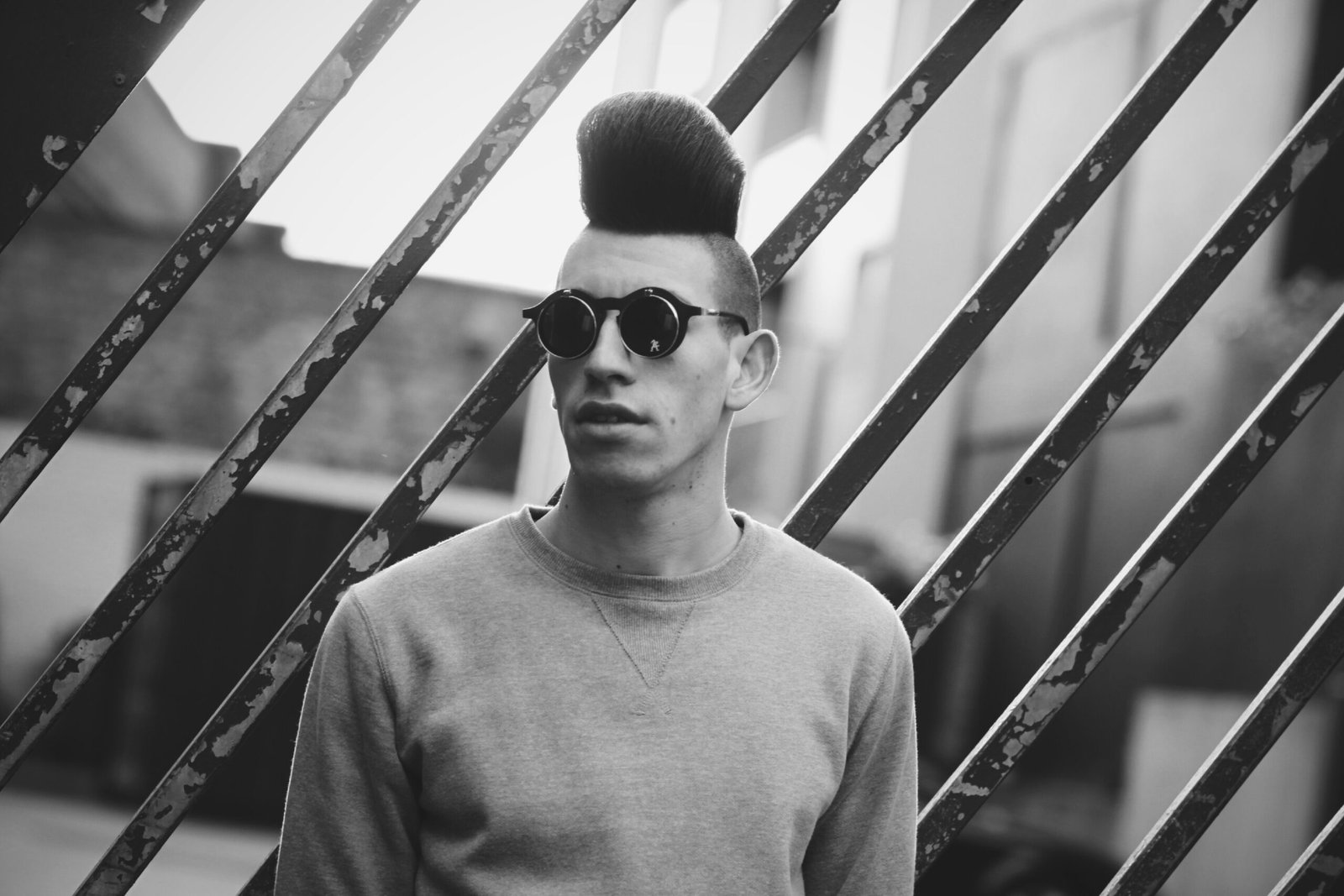 a man with a mohawk undercut wearing sunglasses