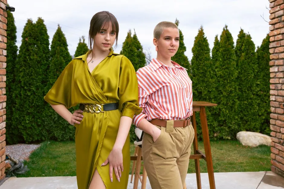 Two women standing confidently in chic outfits, showcasing modern fashion trends.