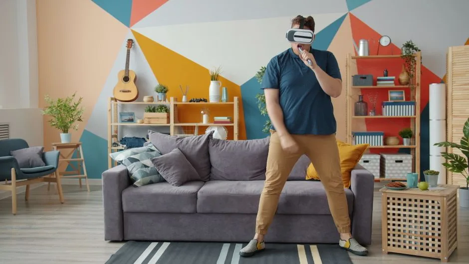 Adult male playing with VR headset in colorful modern living room.