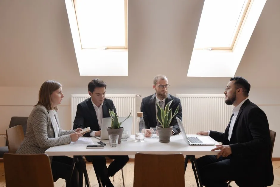 Diverse group of professionals in formal meeting around a table.