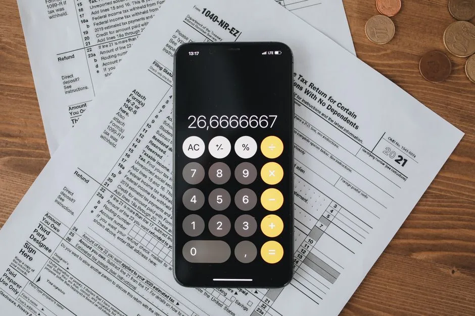 Mobile calculator app on tax documents, highlighting financial calculations and tax preparation.