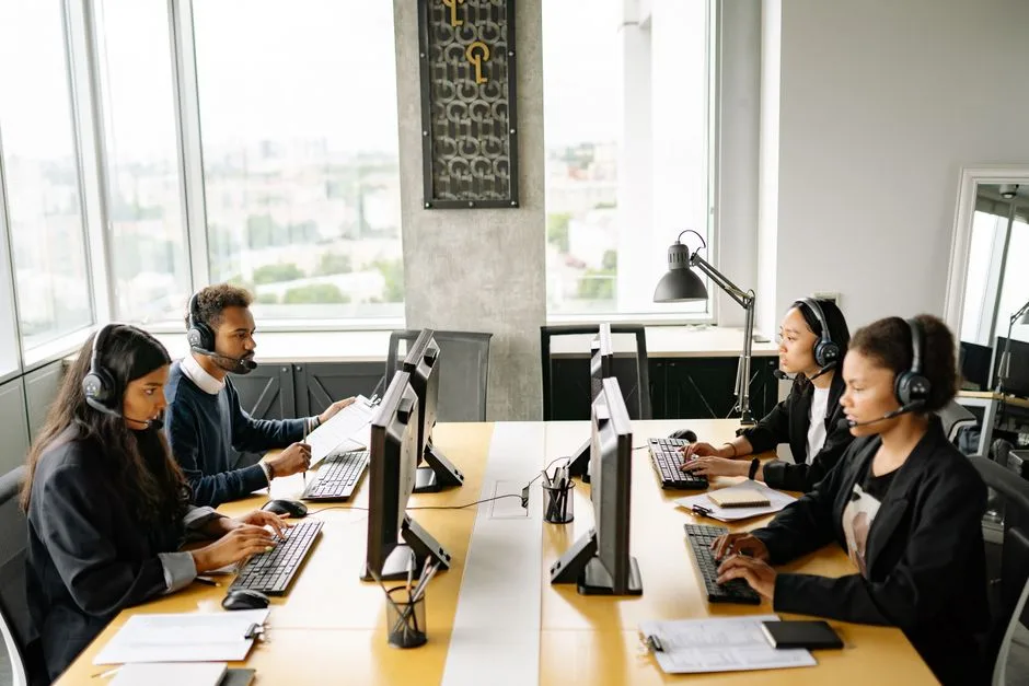 Group of diverse employees working together in a modern office setting, focusing on customer service.