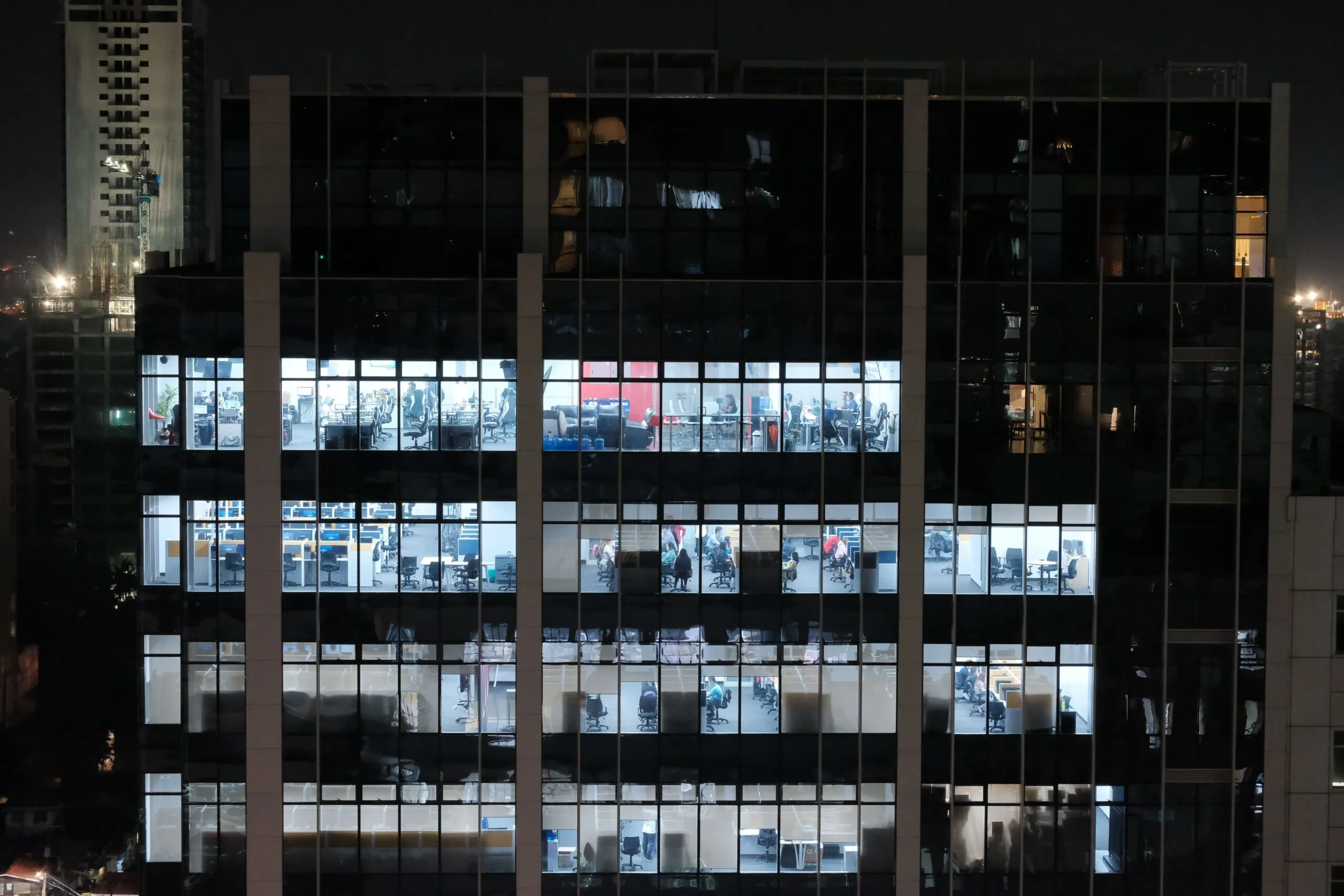A night view of an office building in Central Visayas, Philippines, showcasing illuminated office windows.