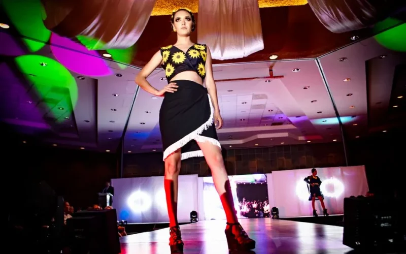 Dynamic fashion model on stage at a vibrant Morelia fashion show.