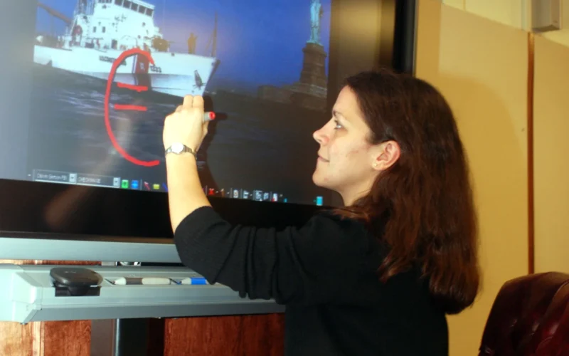 Joelle Laszlo, an assistant with the Center for Legal and Court Technology of William and Mary Law School in Va., demonstrates the on-screen marking capabilities of new audio and video technology recently installed in the Guantanamo Office of Military Commissions courtroom. This new technology enables the courtroom to function on par with modern federal courtrooms in the United States. (JTF Guantanamo photo by Army Spc. Shanita Simmons)
