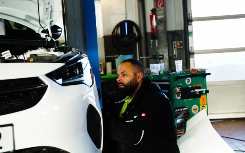 Mechanic working on a car engine in a modern workshop in Gladbeck, NRW, Germany.