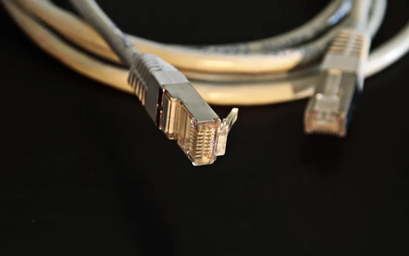 Detailed close-up of a network Ethernet cable showing connectors on a black background.