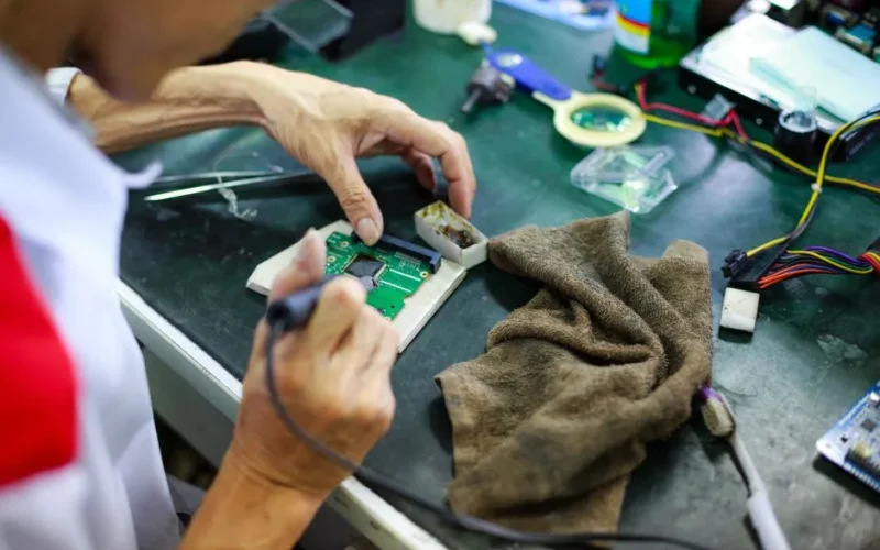 Technician expertly repairing a circuit board, showcasing skill and precision.