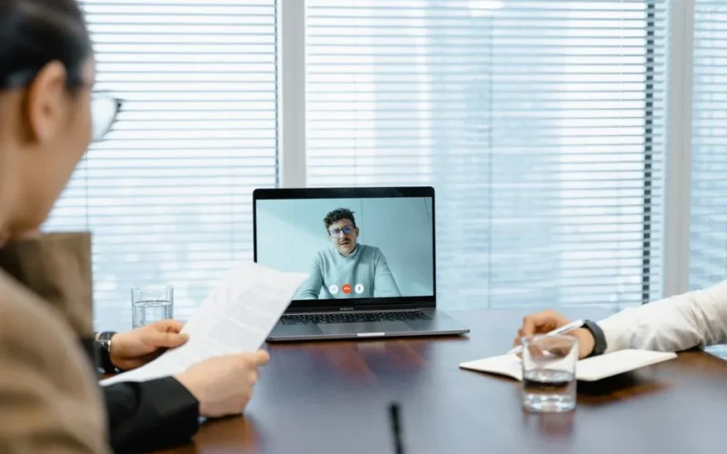 Diverse team in a meeting with remote participant on video call.