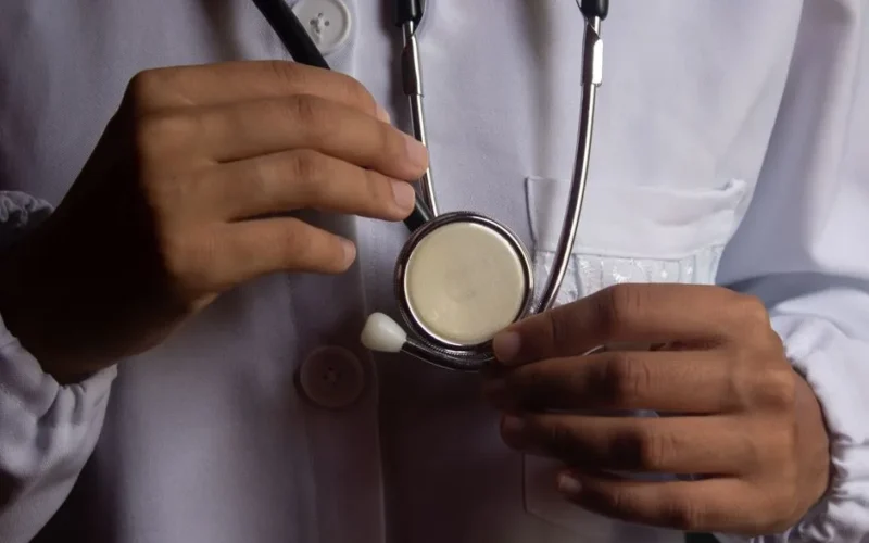 A close-up image showing a doctor holding a stethoscope, symbolizing healthcare and medical practice.