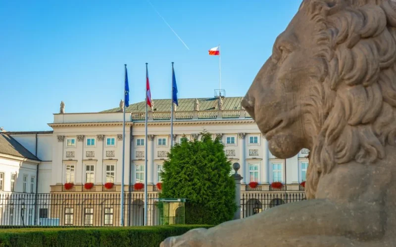 Elegant view of Presidential Palace in Warsaw with a prominent stone lion statue.