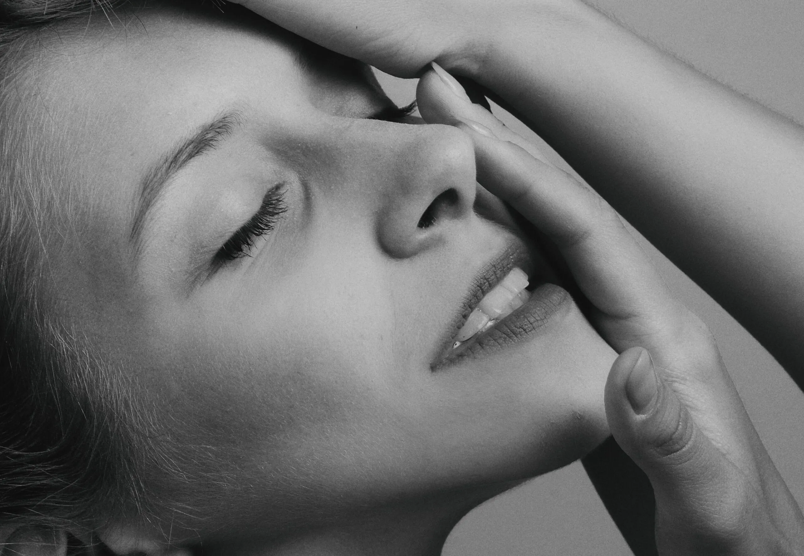 Close-up of a young woman's serene expression in monochrome.