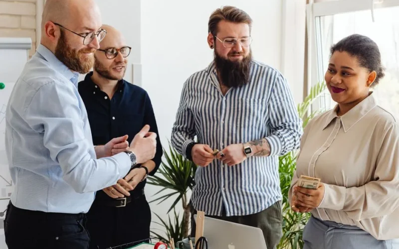 Colleagues sharing ideas and smiling during a team meeting in a modern office.