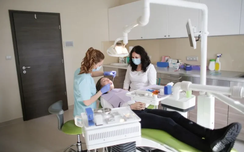 Female dentist performs treatment on a patient in a modern dental clinic.