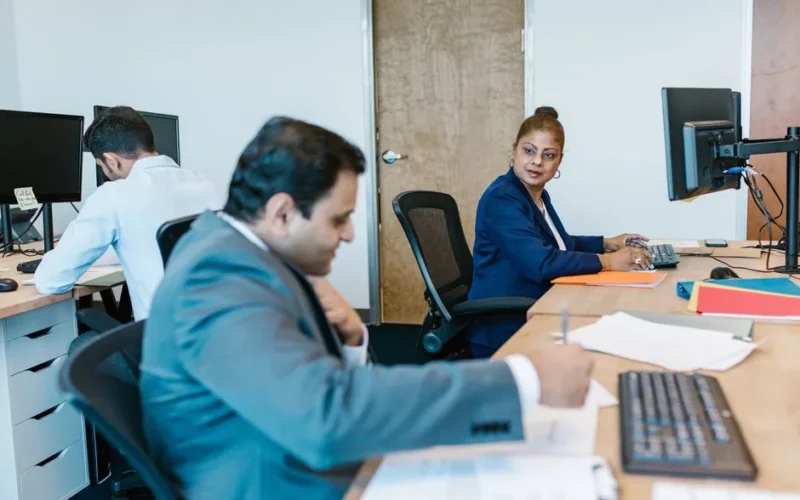 Diverse professionals collaborating in modern office setting, fostering teamwork.