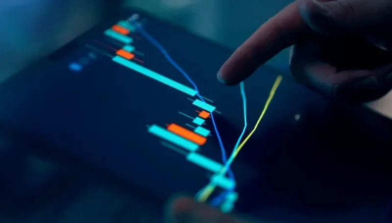 Close-up of a finger interacting with a digital chart on a tablet, depicting financial data and analysis.