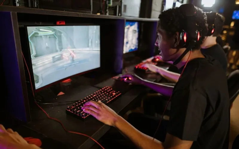 Focused gamers playing on high-performance computers in a cyber cafe. Capturing the intensity of an online gaming session.