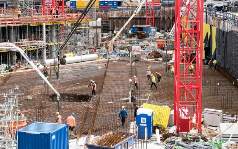 A bustling construction site in Hamburg with workers and equipment actively engaged in building tasks.