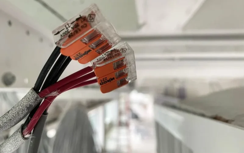 Detailed view of splicing connectors and wires in an indoor setting, ideal for technology-related projects.