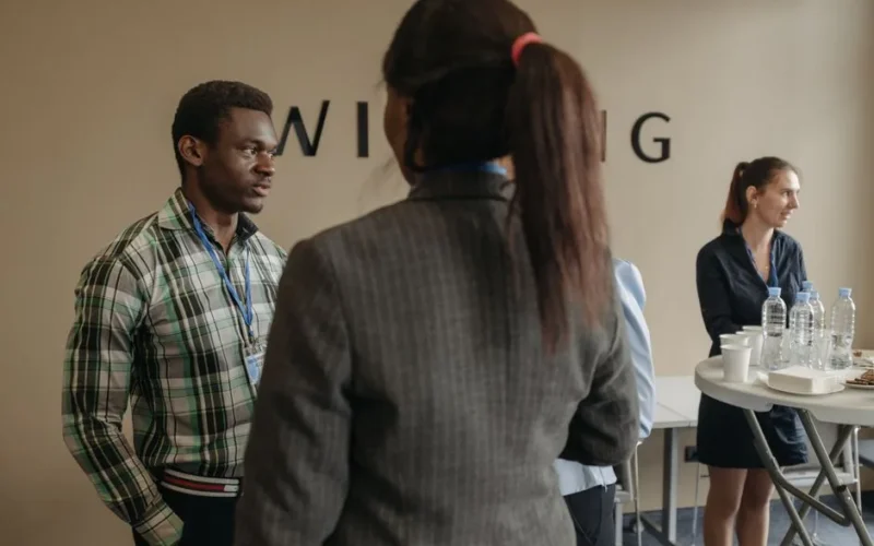 A diverse group of professionals networking at an indoor business seminar.