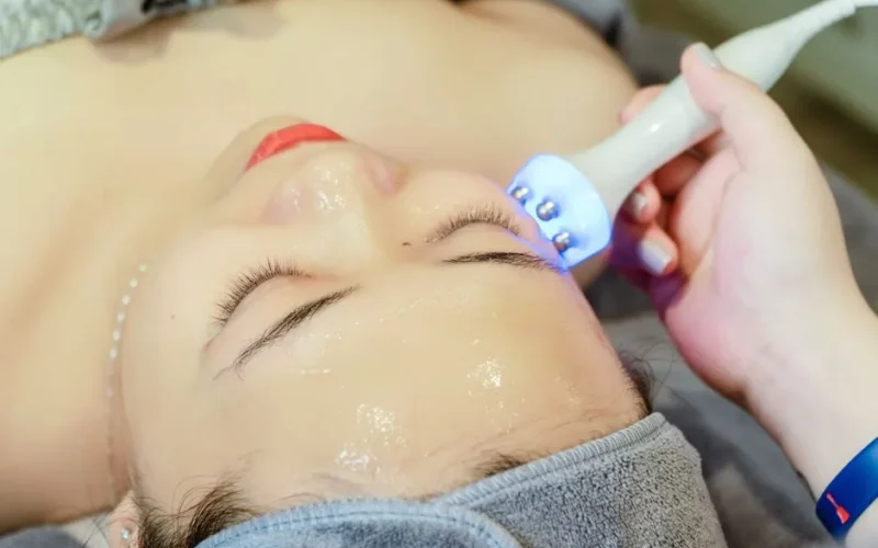 Close-up of a woman receiving an ultrasonic facial treatment in a spa in Hanoi, Vietnam.
