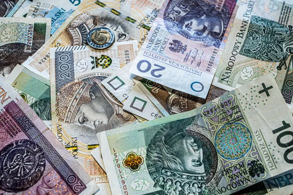 Close-up of various Polish Zloty banknotes and coins, showcasing currency details.