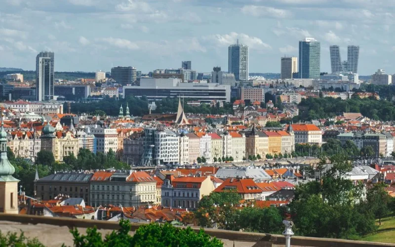 A beautiful cityscape of Prague with historic and modern buildings under clear skies.