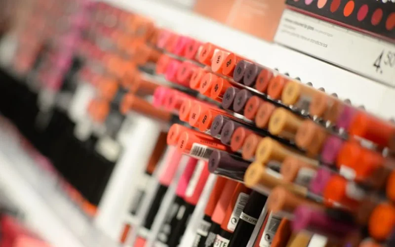 Close-up of diverse lipsticks in a store showcasing various shades and brands for beauty enthusiasts.
